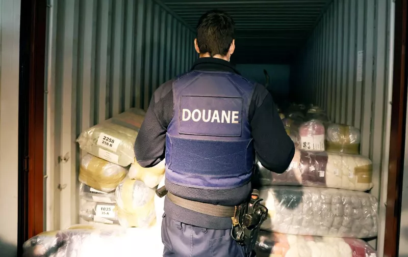 Belgian customs officers and dog search for drugs in a container at Antwerp's port, on January 7, 2022. The amount of cocaine seized in Europe's key port of Antwerp jumped more than 36 percent to a record of nearly 90 tonnes last year, Belgian officials said on January 7, 2022. (Photo by François WALSCHAERTS / AFP)