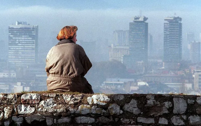 A woman enjoys 17 November 1995 the view of the Sarajevo skyline from a spot shielded from snipers.     AFP PHOTO  ODD ANDERSEN (Photo by ODD ANDERSEN / AFP)