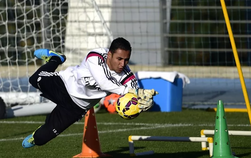 Real Madrid's Costa Rican goalkeeper Keylor Navas stops a ball during a training session at Valdebebas training grounds in Madrid on December 11, 2014.   AFP PHOTO/ PIERRE-PHILIPPE MARCOU