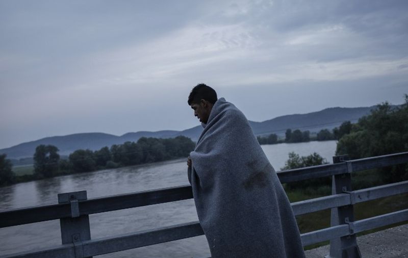 A man covered by a blanket crosses a bridge near Idomeni, Greece, 24 May 2016. Photo: Socrates Baltagiannis/dpa