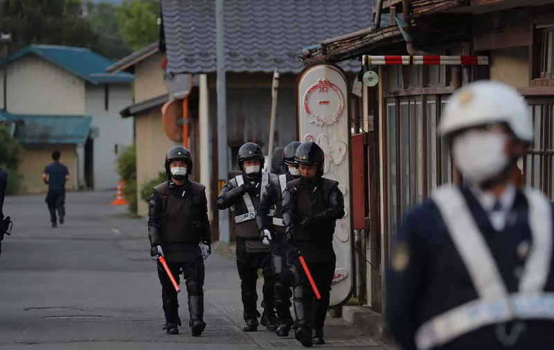 Police officers are seen near the scene of a standoff where a suspect, believed to be a farmer in his 30s, was holed up inside a building in the Ebe area of Nakano, Nagano Prefecture, early morning on May 26, 2023. Japanese police on May 26 detained a suspect who had been holed up in a building after allegedly killing four people including two police officers in a gun and knife attack, an official told AFP. (Photo by JIJI Press / AFP) / Japan OUT