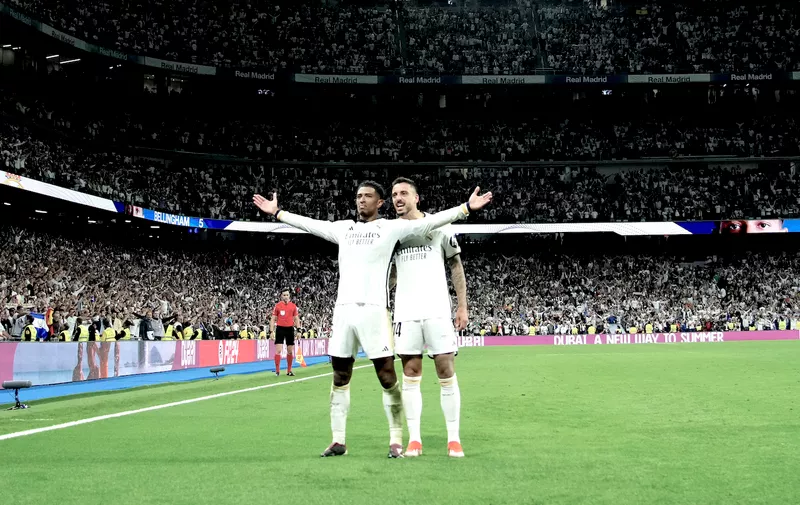 Real Madrid's Jude Bellingham, left, celebrates with Joselu after scoring his side's third goal during the Spanish La Liga soccer match between Real Madrid and Barcelona at the Santiago Bernabeu stadium in Madrid, Spain, Sunday, April 21, 2024. (AP Photo/Jose Breton)