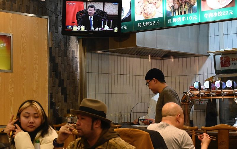 A television screen at a restaurant broadcasts Chinese president Xi Jinping meeting Hong Kong Chief Executive Carrie Lam during her annual duty visit, in Beijing on December 22, 2021. (Photo by JADE GAO / AFP)