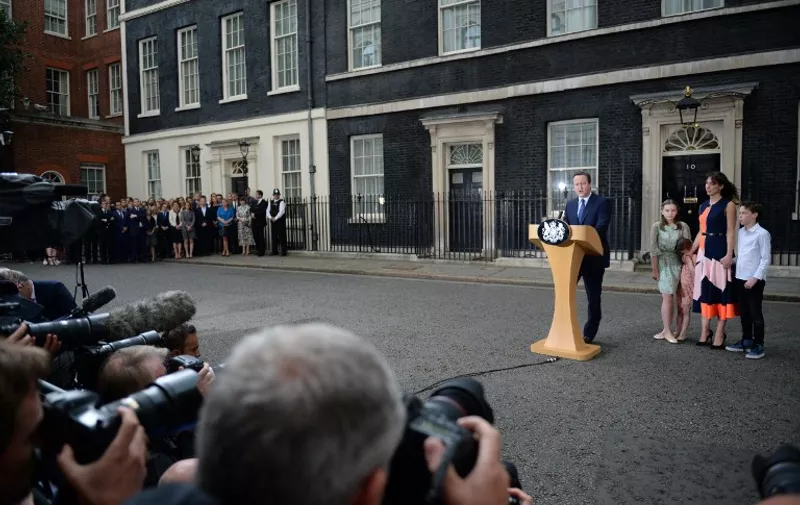 Cameras are trained on outgoing British prime minister David Cameron as he speaks beside (L-R) his daughter Nancy Gwen, daughter Florence Rose Endellion, his wife Samantha Cameron and son Arthur Elwen outside 10 Downing Street in central London on July 13, 2016 before going to Buckingham Palace to tender his resignation to Queen Elizabeth II. 
Outgoing British prime minister David Cameron urged his successor Theresa May on Wednesday to maintain close ties with the EU even while negotiating to leave it, as he paid a fond farewell to MPs hours before leaving office. Cameron will tender his resignation on July 13 to Queen Elizabeth II at Buckingham Palace, after which the monarch will task the new leader of the Conservative Party Theresa May with forming a government.
 / AFP PHOTO / OLI SCARFF