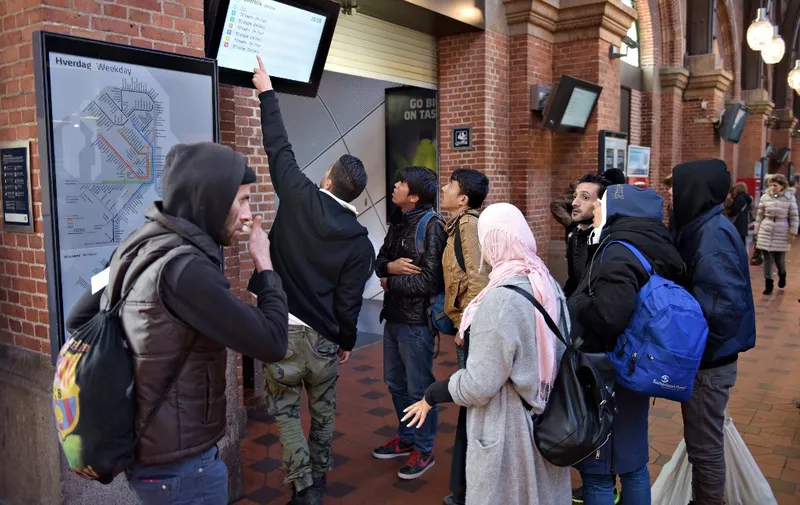 A group of migrants is checking a departure board at Copenhagen Central Station November 12, 2015. The Swedish government on November 11, 2015 said it would temporarily reinstate border checks to deal with an unprecedented influx of migrants, making it the latest country in Europe's passport-free Schengen zone to tighten its borders over the crisis. AFP PHOTO / SCANPIX DENMARK / ASGER LADEFOGED  +++ DENMARK OUT+++ (Photo by Asger Ladefoged / SCANPIX DENMARK / AFP)
