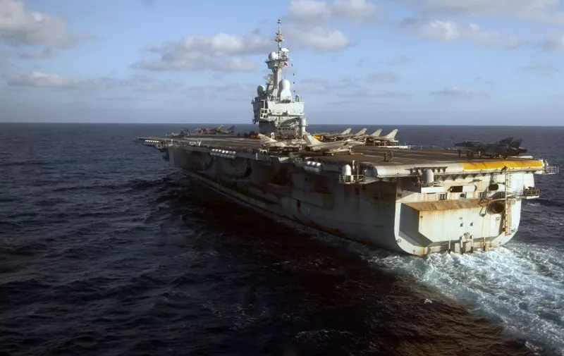 (FILES) A file picture taken on June 13, 2011 shows the French Charles de Gaulle aircraft carrier sailing off the Libyan coast, during the Harmattan operation, the codename for the 2011 French military intervention in Libya. The Elysee announced on November 5, 2015 the deployment of the Charles de Gaulle aircraft carrier to participate in operations against the Islamic State group Daesh, after a restricted defense council.  AFP PHOTO / JOEL SAGET