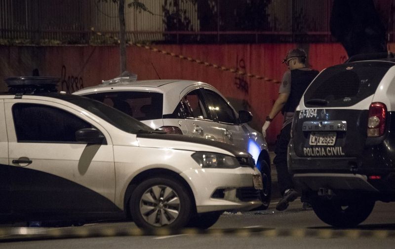 Rio's Civil Police officers investigate at Brazilian politician Marielle Franco's car, where she was found shot dead in Rio de Janeiro, Brazil on March 15, 2018. - Marielle was elected as Rio's councilwoman through Brazilian left-wing party PSOL. Marielle Franco was killed when she was returning from an event in Lapa neighborhood, downtown Rio de Janeiro. Her driver died too. (Photo by Mauro Pimentel / AFP)