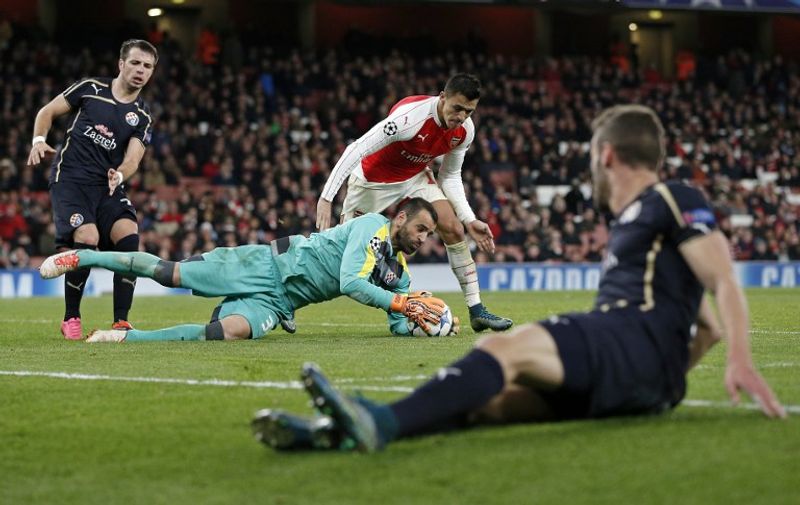 Dinamo Zagreb's goalkeeper from Portugal Eduardo (Below C) defends the ball from Arsenal's Chilean striker Alexis Sanchez (Back 2nd R) during their UEFA Champions League Group F football match between Arsenal and GNK Dinamo Zagreb at The Emirates Stadium in London on November 24, 2015. AFP PHOTO / ADRIAN DENNIS / AFP / ADRIAN DENNIS