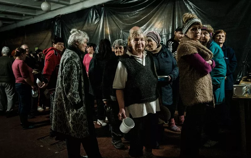 Internally displaced people wait for food distribution in a bunker at a factory in Severodonetsk, eastern Ukraine, on April 22, 2022 amid the Russian invasion of Ukraine. (Photo by Yasuyoshi CHIBA / AFP)