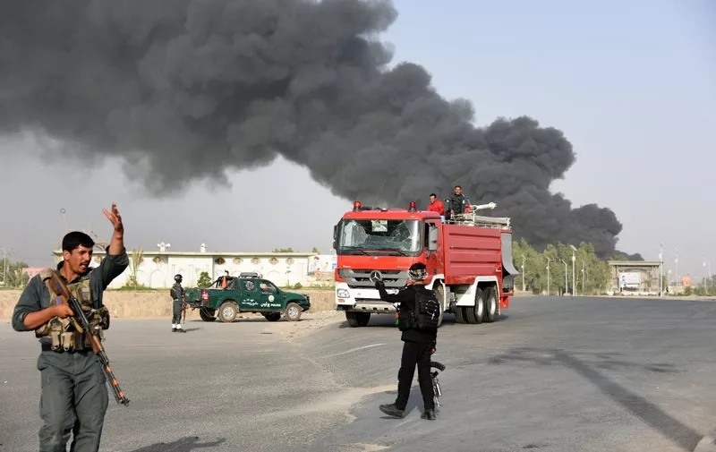 Afghan policemen arrive near a site of car bomb attack as smoke rises from the Police headquarters in Kandahar province on July 18, 2019. (Photo by JAVED TANVEER / AFP)