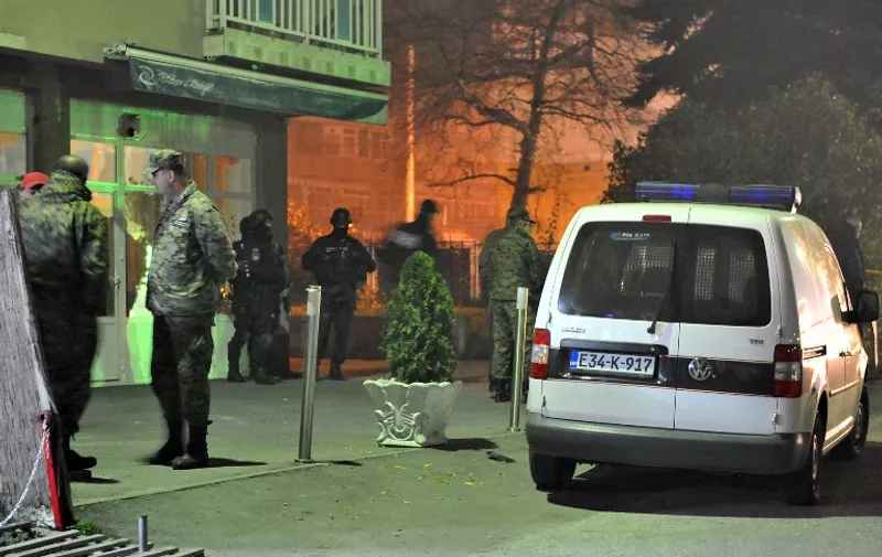 Bosnian military personnel are seen working with police  during an investigation in Sarajevo's Northern suburb of Rajlovac  late on November 18, 2015, after an attack by an armed suspect. Two soldiers from the Bosnian army were shot dead when the gunman used an automatic weapon to shoot a  betting shop near army barracks. The gunman also shot at a bus when fleeing the area, injuring an additional three people.  AFP PHOTO/  ELVIS BARUKCIC