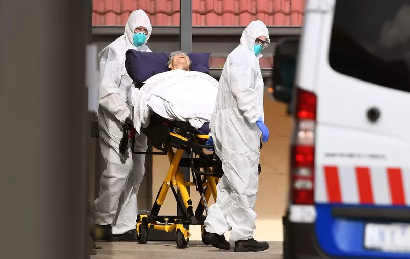 Ambulance officers remove a resident from the St Basil's Home for the Aged in the Melbourne suburb of Fawkner on July 27, 2020, with 84 cases of the COVID-19 coronavirus linked to the facility. - The Australian state of Victoria has recorded 532 new coronavirus cases, the highest one-day total in the state since the pandemic started. (Photo by William WEST / AFP)