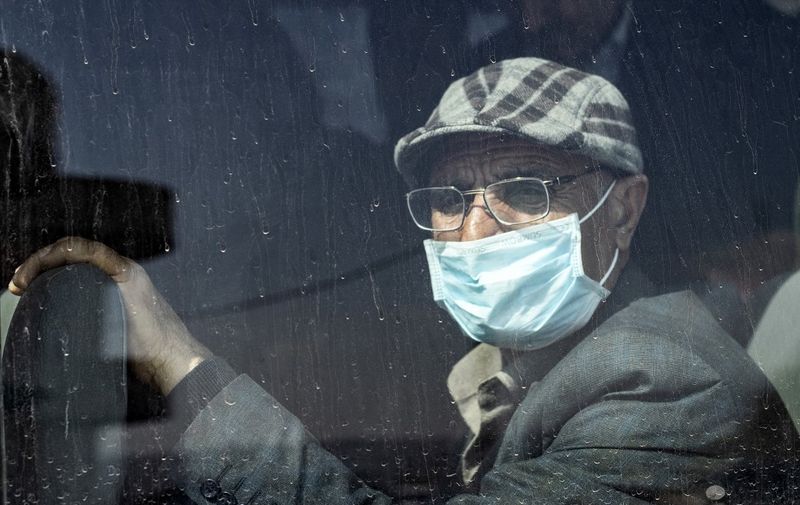 A passengers wears a mask as a preventive measure against the coronavirus upon his arrival by bus in Syria's Kurdish area from Iraqi Kurdistan via the Semalka border crossing in northeastern Syria on February 26, 2020. (Photo by Delil SOULEIMAN / AFP)