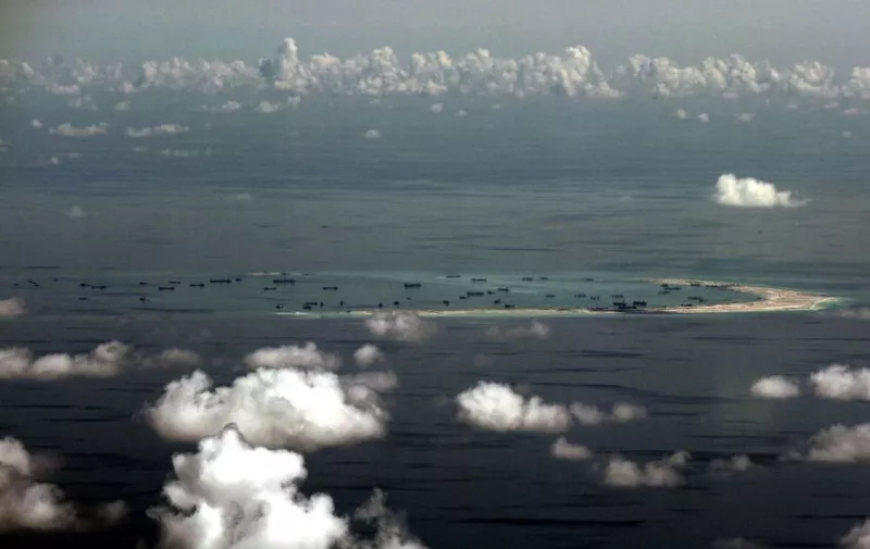 This aerial photograph taken from a military aircraft shows alleged on-going reclamation by China on Mischief Reef in the Spratly group of islands in the South China Sea, west of Palawan, on May 11, 2015. The Spratlys are considered a potential Asian flashpoint, and claimant nations including the Philippines have expressed alarm as China has embarked on massive reclamation activity. AFP PHOTO / POOL / RITCHIE B. TONGO