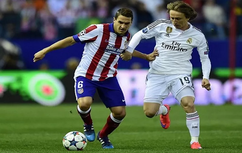 Atletico Madrid&#8217;s midfielder Koke (L) vies with Real Madrid&#8217;s Croatian midfielder Luka Modric during the UEFA Champions League quarter final first leg football match Atletico de Madrid vs Real Madrid CF at the Vicente Calderon stadium in Madrid on April 14, 2015. AFP PHOTO /