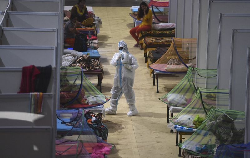 A health worker wearing a personal protective equipment (PPE) suit attends Covid-19 coronavirus patients inside a centre of the Commonwealth Games (CWG) village temporarily converted into a Covid care facility, in New Delhi on May 2, 2021. (Photo by TAUSEEF MUSTAFA / AFP)