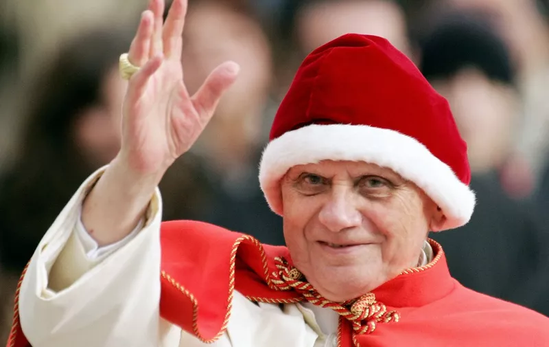 (FILES) In this file photo taken on December 28, 2005 Pope Benedict XVI wearing a Camauro, a red velvet hat with white ermine trim used by popes at the 12th century, waves to the pilgrims as he arrives on St-Peter's square at the Vatican to preside over his weekly general audience. The pontiff prayed for the victims of last year's Asian earthquake and tsunami, which killed at least 220 000 people. - Pope Emeritus Benedict XVI, a German theologian whose 2013 resignation took the world by surprise, died on December 31 2022, at the age of 95, the Vatican announced. (Photo by Patrick HERTZOG / AFP)