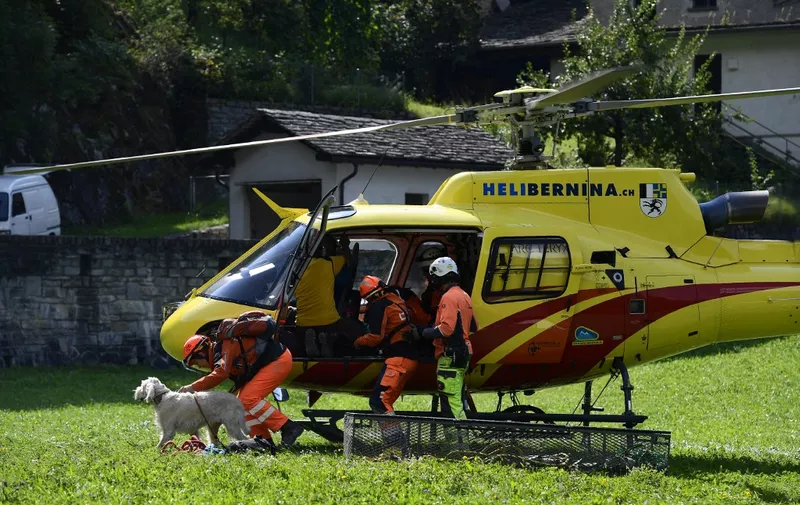 A rescue helicopter lands in the village of Bondo as the search for eight missing people continues after a landslide on August 24, 2017. Rescue workers resumed their search for eight people still missing after a massive landslide in the Swiss Alps while dozens of evacuees waited to return home. The massive search and rescue operation, involving more than 100 emergency workers equipped with infrared cameras and mobile phone detectors, helicopters and rescue dogs, had been halted overnight for safety reasons. (Photo by MIGUEL MEDINA / AFP)