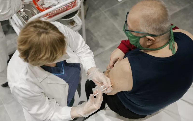 A man receives a Pfizer-BioNTech Covid-19 vaccine at a clinic in Belgrade on January 13, 2021. - Serbia has started vaccinating against the novel coronavirus Covid-19 with Pfizer-BioNTech jab on December 24, 2020.
The health authorities have also authorised, on December 31, the import of the first doses of the Russian vaccine Sputnik V. (Photo by Vladimir Zivojinovic / AFP)