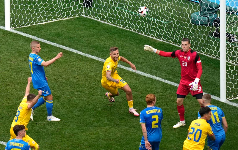 Romania's Denis Dragus, center, celebrates after scoring the third goal against Ukraine during a Group E match between Romania and Ukraine at the Euro 2024 soccer tournament in Munich, Germany, Monday, June 17, 2024. (AP Photo/Ariel Schalit)