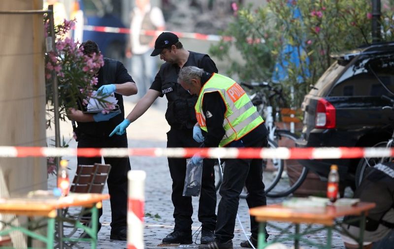 Police investigators work at the site of a suicide bombing in Ansbach, southern Germany, on July 25, 2016. 
A failed Syrian asylum seeker set off an explosive device near an open-air music festival in the southern city of Ansbach that killed himself and wounded a dozen others. / AFP PHOTO / dpa / Daniel Karmann / Germany OUT