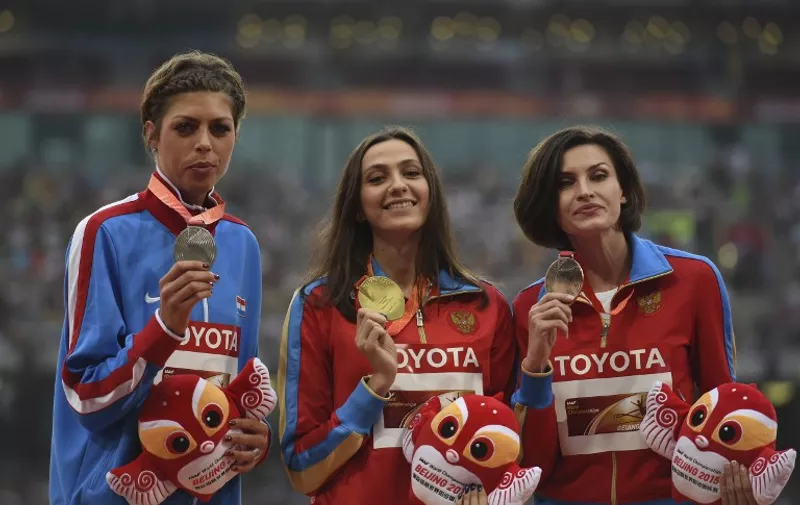(L-R) Silver medallist Croatia's Blanka Vlasic, gold medallist Russia's Maria Kuchina and bronze medallist Russia's Anna Chicherova celebrate on the podium during the victory ceremony for the women's high jump athletics event at the 2015 IAAF World Championships at the "Bird's Nest" National Stadium in Beijing on August 30, 2015.  AFP PHOTO / GREG BAKER / AFP / GREG BAKER