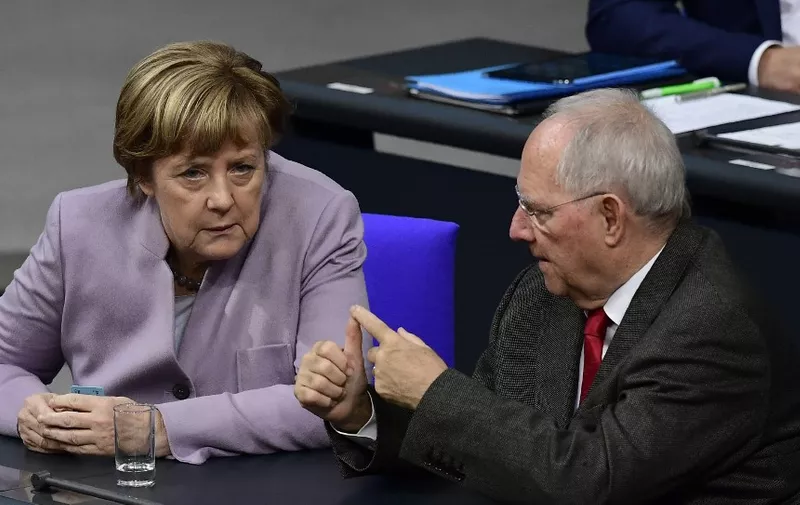(FILES) Then German Chancellor Angela Merkel talks with then German Finance Minister Wolfgang Schaeuble during a session at the Bundestag (lower house of parliament) in Berlin on November 25, 2016, during a week of budget debate. Wolfgang Schaeuble, one of the most important figures in German political life over the last 30 years, has died aged 81, a source from the conservative CDU-CSU alliance told AFP on December 27, 2023. (Photo by TOBIAS SCHWARZ / AFP)
