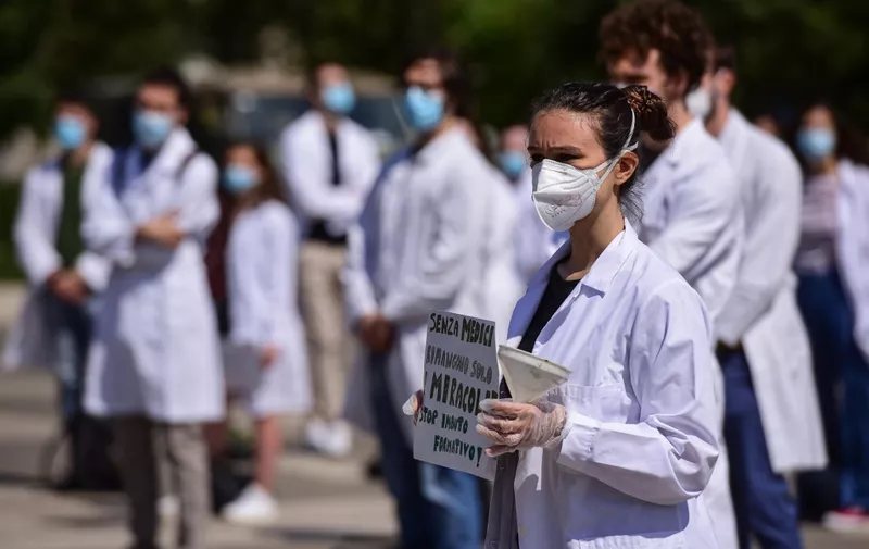 A medical student holds a placard reading 'Without doctors, only miracles remain' during a protest of medical students, newly qualified doctors and doctors in training outside Milan's Central railway station on May 29, 2020, asking for an educational reform of medical training, as the country eases its lockdown measures aimed at curbing the spread of the COVID-19 infection, caused by the novel coronavirus. (Photo by Piero Cruciatti / AFP)