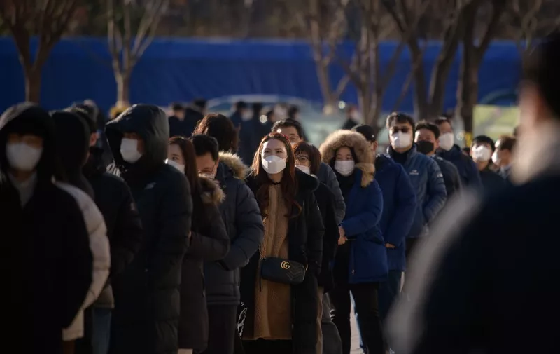 Office workers and city government employees queue at a temporary covid-19 novel coronavirus testing centre outside city hall in Seoul on December 17, 2020. (Photo by Ed JONES / AFP)