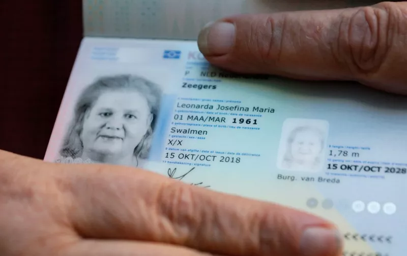 Leonne Zeegers, 57, receives a passeport with the gender designation X, instead of M for man or V for woman in Breda, on October 19, 2018. - The first gender-neutral passport of The Netherlands was issued. (Photo by Bas Czerwinski / ANP / AFP) / Netherlands OUT