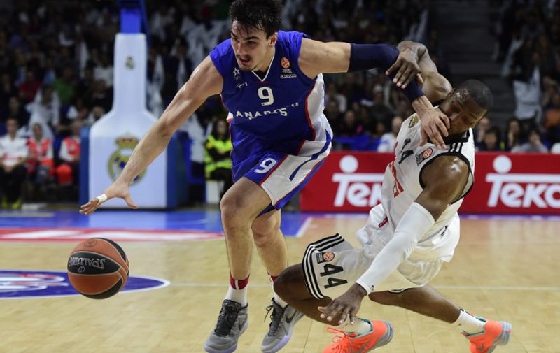 Anadolu Efes Istanbul's Croatian forward Dario Saric (L) vies with Real Madrid's US forward Marcus Slaughter during the Euroleague playoff basketball match Real Madrid vs Anadolu Efes Istambul at the Barclaycard Center in Madrid on April 15, 2015.   AFP PHOTO / JAVIER SORIANO / AFP / JAVIER SORIANO