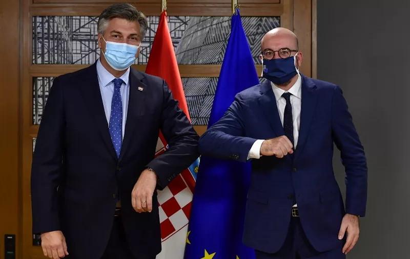 European Council President Charles Michel (R) touches elbows as he greets Croatia's Prime Minister Andrej Plenkovic ahead of a bi-lateral meeting on the first day of a European Union (EU) summit at The European Council Building in Brussels on October 1, 2020. (Photo by JOHN THYS / various sources / AFP)