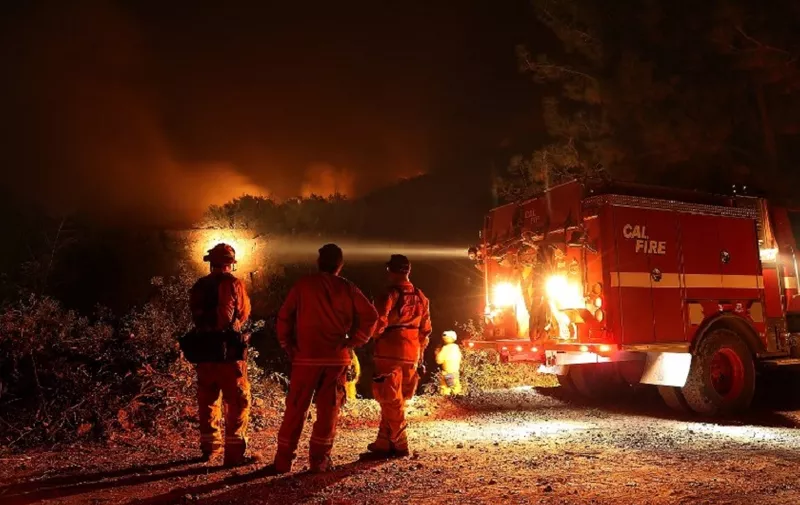 LODOGA, CA - AUGUST 07: Cal Fire firefighters monitor a back fire while battling the Medocino Complex fire on August 7, 2018 near Lodoga, California. The Mendocino Complex Fire, which is made up of the River Fire and Ranch Fire, has surpassed the Thomas Fire to become the largest wildfire in California state history with over 280,000 acres charred and at least 75 homes destroyed.   Justin Sullivan/Getty Images/AFP