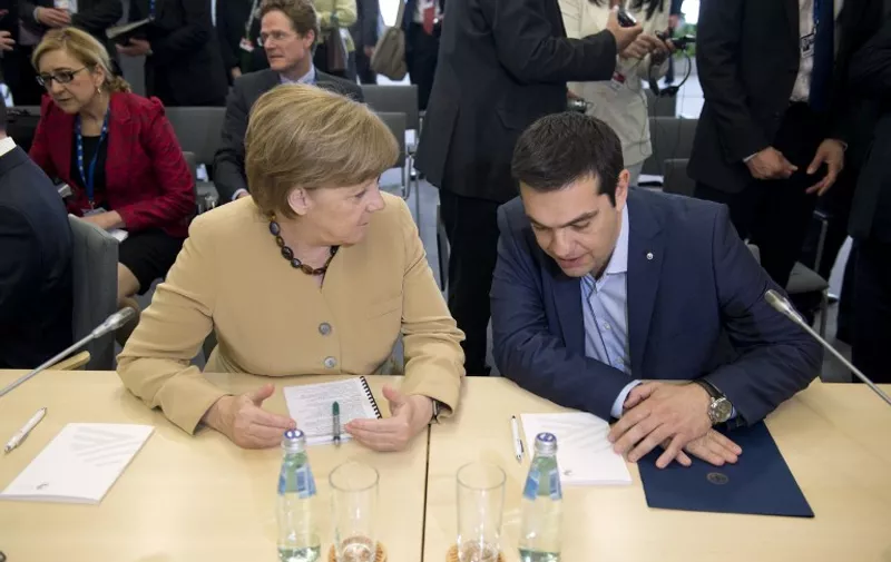 German chancellor Angela Merkel (L) talks with Greek prime minister Alexis Tsipras at the begining of the second day of  the fourth European Union (EU) eastern Partnership Summit in Riga, on May 22, 2015 as Latvia holds the rotating presidency of the EU Council. EU leaders and their counterparts from Ukraine and five ex-Soviet states hold a summit focused on bolstering their ties, an initiative that has been undermined by Russia's intervention in Ukraine. AFP PHOTO / ALAIN JOCARD