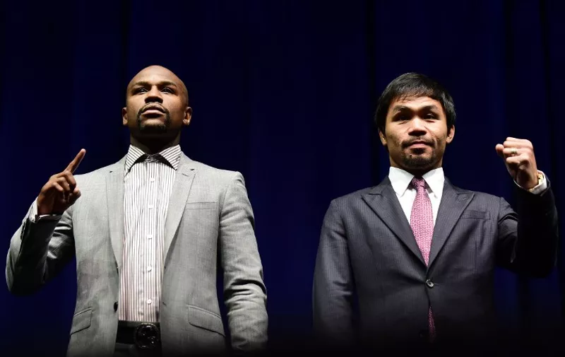 Boxers Manny Pacquiao (R) from the Philippines and Floyd Mayweather from the US gesture while posing during a press conference on March 11, 2015 in Los Angeles, California, to launch the countdown to their May 2, 2015 super-fight in Las Vegas. AFP PHOTO/ FREDERIC J. BROWN