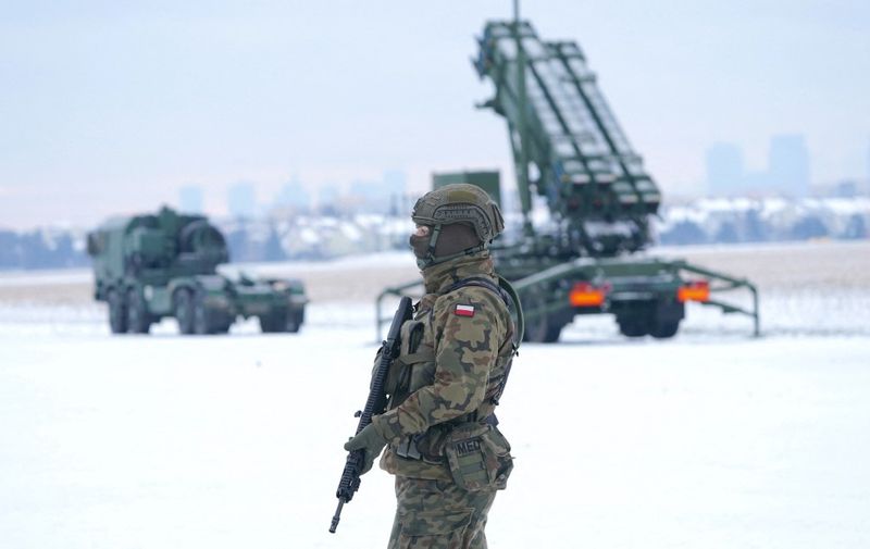 A soldier stands in front of a PATRIOT (Phased Array Tracking Radar to Intercept on Target) surface-to-air missile system during a military exercise at Warsaw Babice Airport, Poland on February 7, 2023. Patriot missile systems purchased by Poland last year have been redeployed to the Polish captital for military exercises. (Photo by JANEK SKARZYNSKI / AFP)
