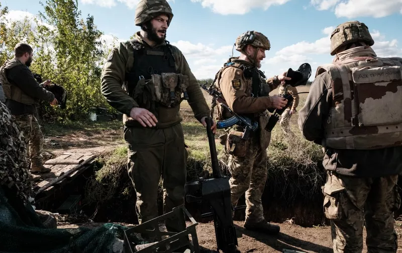 A soldier (3rd R) of Ukraine's 5th Regiment of Assault Infantry holds a US-made MK-19 automatic grenade launcher after firing towards Russian positions in less than 800 metres away at a front line near Toretsk in the Donetsk region on October 12, 2022, amid the Russian invasion of Ukraine. (Photo by Yasuyoshi CHIBA / AFP)