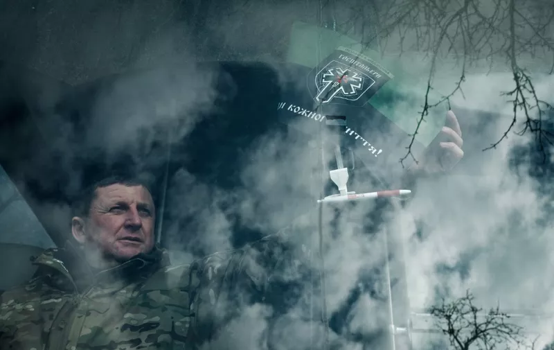A staff holds the flag of the volunteer medical battalion Hospitallers, which helps with medical evacuations of wounded Ukrainian servicemen, at the drivers seat on their medical evacuation bus in Donetsk region on February 11, 2023, amid the Russian invasion of Ukraine. - The medical evacuation bus called "Austrian was named after the call sign of the Ukrainian doctor Natalia Frauscher who lived in Austria and died in a traffic accident during her duty on the previous medical evacuation bus last June. (Photo by YASUYOSHI CHIBA / AFP)