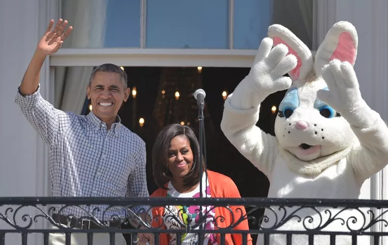 US President Barack Obama, First Lady Michelle Obama and the &#8220;Easter Bunny&#8221; arrive on the balcony for the start for the annual Easter egg roll on the South Lawn of the White House on April 6, 2015 in Washington, DC. AFP PHOTO/MANDEL NGAN