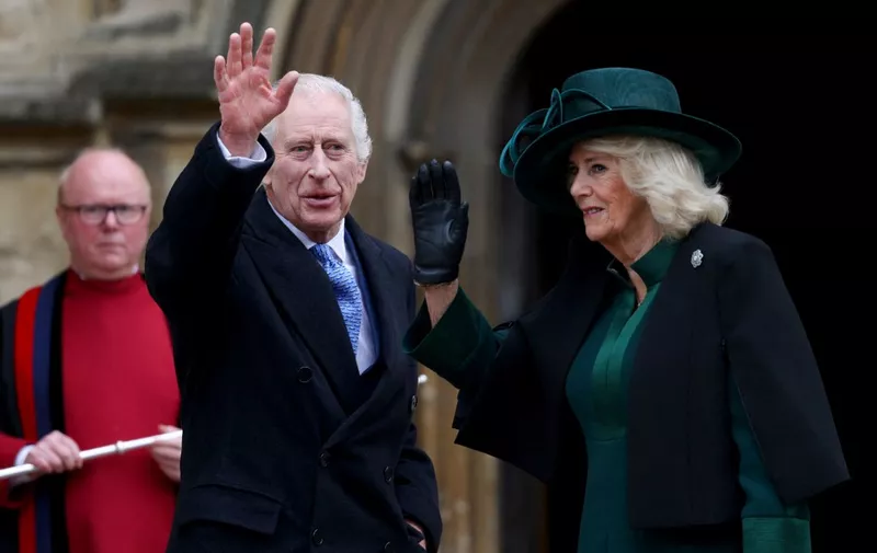 Britain's King Charles III (C) and Britain's Queen Camilla (R) waves as they arrive at St. George's Chapel, Windsor Castle, to attend the Easter Mattins Service, on March 31, 2024. (Photo by Hollie Adams / POOL / AFP)