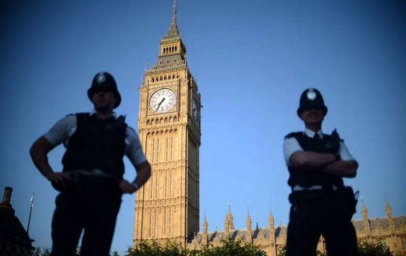 Two policemen stand in front of the  "Big Ben" clock Tower in central London on July 22, 2012, five days before the start of the London 2012 Olympic Games. AFP PHOTO / JOHANNES EISELE / AFP / JOHANNES EISELE