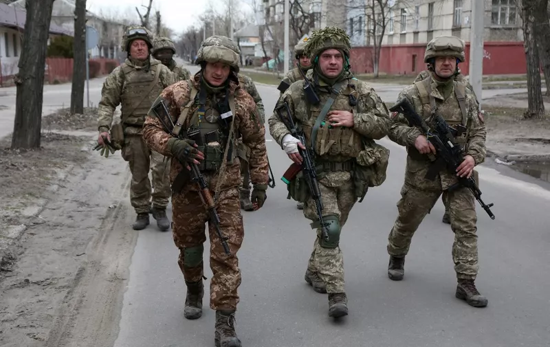 Servicemen of Ukrainian Military Forces walk in the small town of Sievierodonetsk, Lugansk Oblast, on February 27, 2022. - Ukraine said that it had agreed to send a delegation to meet Russian representatives at the border with Belarus, which has allowed Russian troops passage to attack Ukraine, insisting there were no pre-conditions to the talks. (Photo by Anatolii STEPANOV / AFP) / The erroneous mention[s] appearing in the metadata of this photo by Anatolii Stepanov has been modified in AFP systems in the following manner: [Sievierodonetsk, Lugansk Oblast] instead of [Severodonetsk, Donetsk region]. Please immediately remove the erroneous mention[s] from all your online services and delete it (them) from your servers. If you have been authorized by AFP to distribute it (them) to third parties, please ensure that the same actions are carried out by them. Failure to promptly comply with these instructions will entail liability on your part for any continued or post notification usage. Therefore we thank you very much for all your attention and prompt action. We are sorry for the inconvenience this notification may cause and remain at your disposal for any further information you may require.