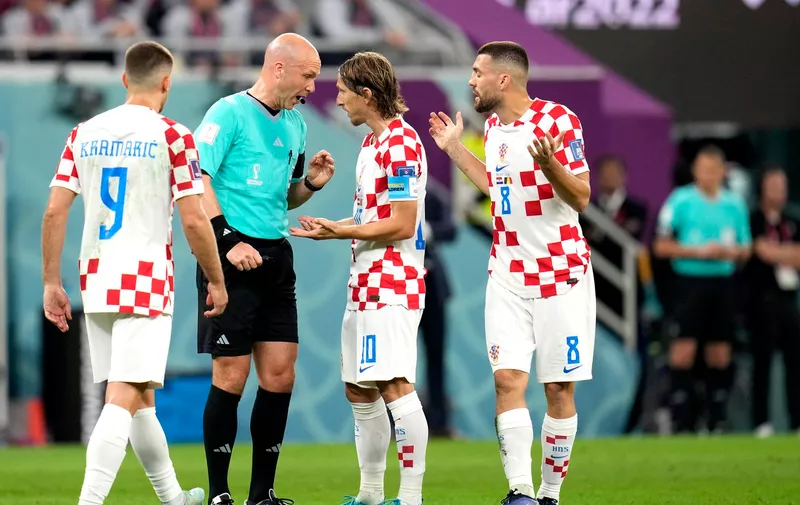 Croatia's Luka Modric, second from right, with teammate protest to the referee Anthony Taylor for reversing a penalty kick after his VAR review during the World Cup group F soccer match between Croatia and Belgium at the Ahmad Bin Ali Stadium in Al Rayyan , Qatar, Thursday, Dec. 1, 2022. (AP Photo/Ricardo Mazalan)