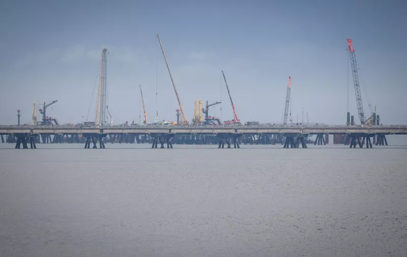 The construction site of the Uniper Liquefied Natural Gas (LNG) terminal at the Jade Bight in Wilhelmshaven on the North Sea coast, northwestern Germany, is pictured on September 29, 2022. - The terminal for the import of LNG is planned to come online at the end of 2023. Germany is looking to wean itself off Russian pipeline imports and secure supplies for future winters by diversifying natural gas supply sources. (Photo by FOCKE STRANGMANN / AFP)