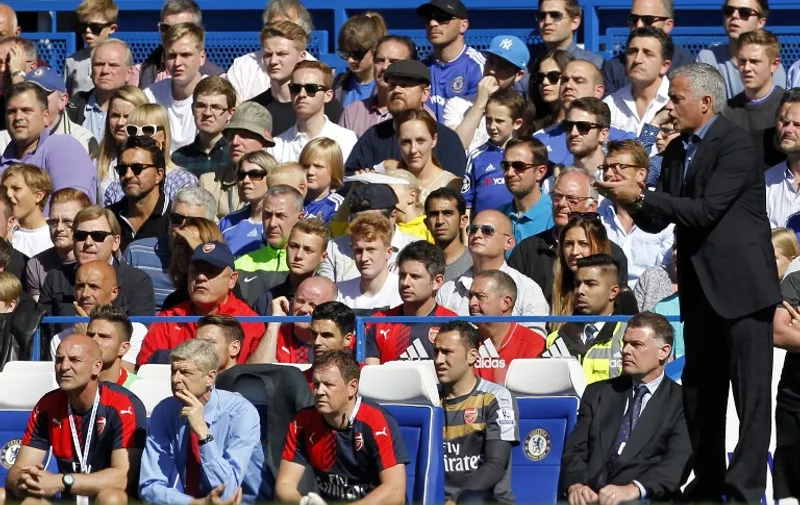 Chelsea's Portuguese manager Jose Mourinho (R) gestures as Arsenal's French manager Arsene Wenger (front row 2nd L) sits watching the English Premier League football match between Chelsea and Arsenal at Stamford Bridge in London on September 19, 2015. AFP PHOTO / IAN KINGTON 

RESTRICTED TO EDITORIAL USE. No use with unauthorized audio, video, data, fixture lists, club/league logos or 'live' services. Online in-match use limited to 75 images, no video emulation. No use in betting, games or single club/league/player publications.