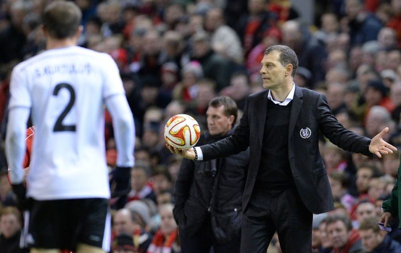 Besiktas' Croatian coach Slaven Bilic (R) collects the ball on the touchline during the UEFA Europa League round of 32 first leg football match between Liverpool and Besiktas at Anfield in Liverpool, northwest England, on February 19, 2015.  AFP PHOTO / 