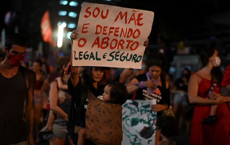 A woman holds a sign in support of legal abortion during a demonstration to commemorate the International Womens Day at the city center of Rio de Janeiro, Brazil, March 08, 2022. (Photo by MAURO PIMENTEL / AFP)