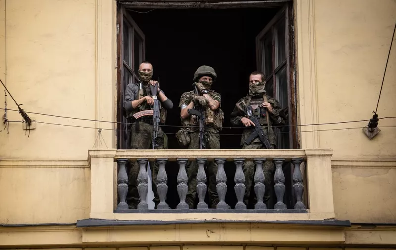 Members of Wagner group stand on the balcony of the circus building in the city of Rostov-on-Don, on June 24, 2023. President Vladimir Putin on June 24, 2023 said an armed mutiny by Wagner mercenaries was a "stab in the back" and that the group's chief Yevgeny Prigozhin had betrayed Russia, as he vowed to punish the dissidents. Prigozhin said his fighters control key military sites in the southern city of Rostov-on-Don. (Photo by Roman ROMOKHOV / AFP)