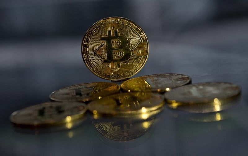 Gold plated souvenir Bitcoin coins are arranged for a photograph in London on November 20, 2017. 
Bitcoin, a type of cryptocurrency, uses peer-to-peer technology to operate with no central authority or banks. Bitcoin's recent rise and booming investor interest is forcing the regulatory and stock market authorities to formulate an official position on bitcoin and other virtual currencies, which are controversial not only because of their speculative nature, but are also seen as vehicles for illegal activities. / AFP PHOTO / Justin TALLIS