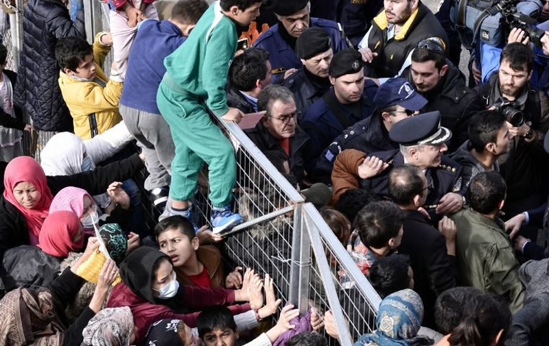 Migrants block the entrance of the Hellinikon camp in Athens in protest at poor living conditions on February 6, 2017, during a visit of Greek Immigration Minister Yiannis Mouzalas (C-R top).
The demonstration broke out at the former Hellinikon airport's camp near Athens, which houses hundreds of predominantly Afghan migrants who had announced a hunger strike hours earlier. A disused Olympic park, Hellinikon houses over 1,500 migrants who say the run-down stadiums are unsuited to long-term habitation. At the start of the major influx in 2015, Afghans were originally viewed as refugees and allowed to continue their journey from Greece to other countries in Europe. But many now face deportation -- despite growing insecurity that saw civilian casualties in Afghanistan hit a record high in 2016 -- after a disputed deal between EU and Kabul to send migrants back. / AFP PHOTO / LOUISA GOULIAMAKI